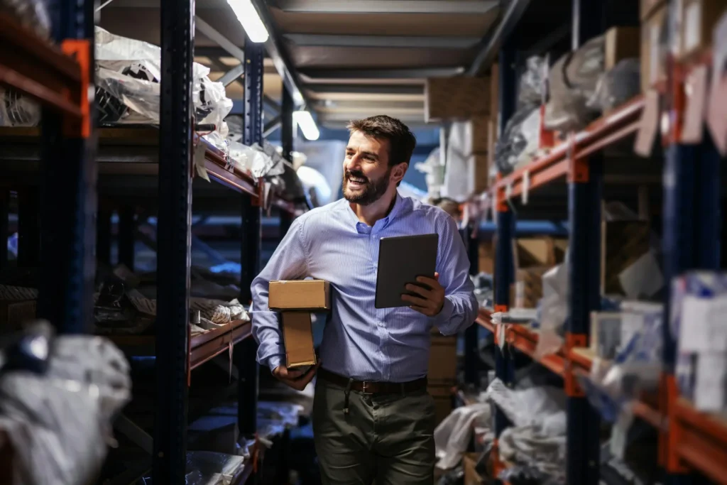 A business professional managing inventory in a warehouse, symbolising employer-sponsored visa pathways and skilled migration support in Australia.